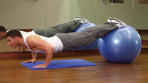 Bonito homem desportivo está se exercitando no centro de fitness — Vídeo de Stock