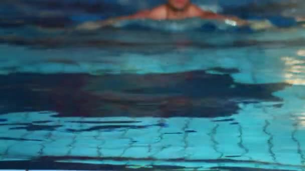 Handsome guy is swimming to side of the pool — Stock Video