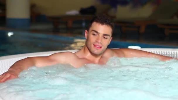 Schöner Mann entspannt sich im Whirlpool — Stockvideo