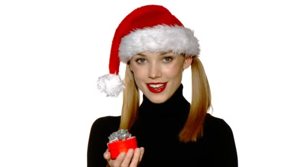 Sexy dívka v klobouku santa claus ukazující dar v poli — Stock video