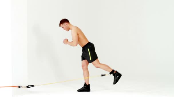 Красивый мускулистый мужчина тренируется с резиной на белом — стоковое видео