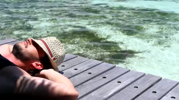 Hombre guapo descansando cerca del agua en Maldivas — Vídeos de Stock