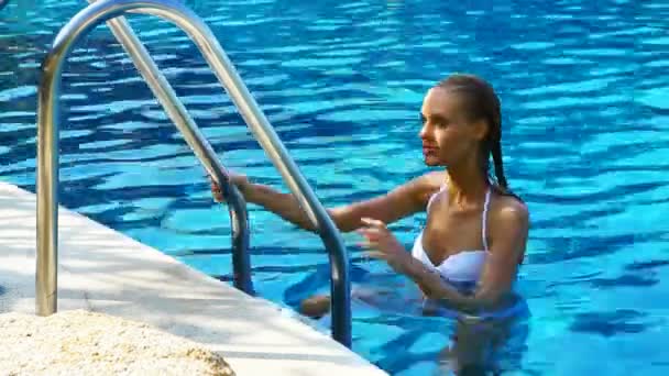 Sexy woman climbing a swimming pool ladder — Stock Video