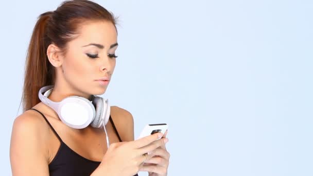 Молодая девушка ищет музыку на своем плеере — стоковое видео