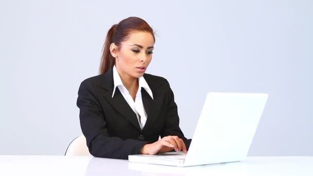 Mujer de negocios sentada en el escritorio y usando computadora portátil — Vídeos de Stock