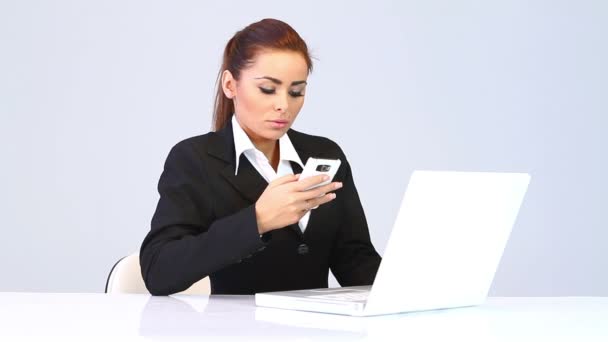 Business woman sitting at the desk and talking mobile phone — Stock Video