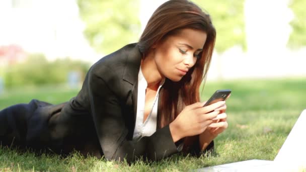 Belle femme d'affaires se détendre sur l'herbe avec ordinateur portable — Video