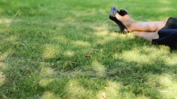 Schöne Geschäftsfrau entspannt sich mit Laptop im Gras — Stockvideo