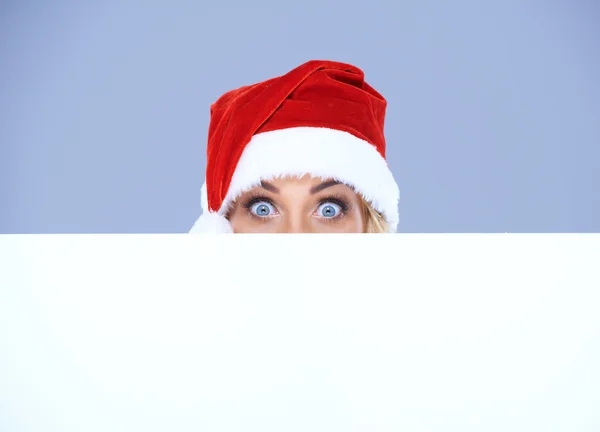 Tête et yeux de femme avec chapeau de Père Noël au-dessus du tableau blanc — Photo