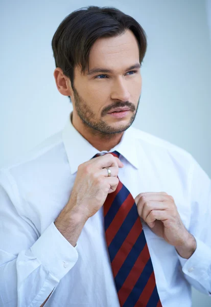 Hombre atractivo enderezando su corbata —  Fotos de Stock