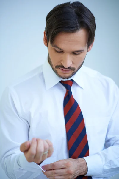 Attraktiver junger Mann, der seine Hemdmanschetten hochzieht — Stockfoto