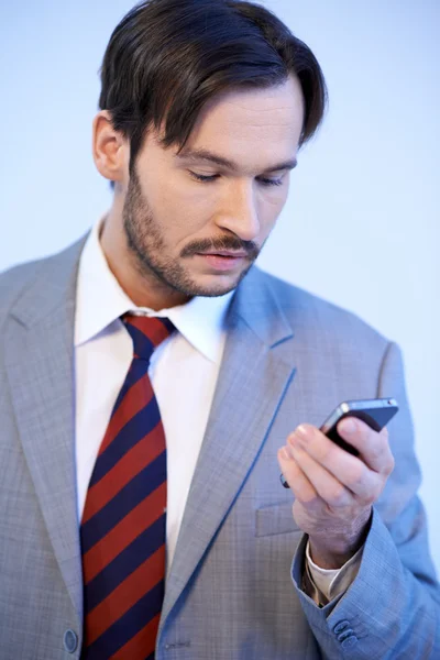 Человек, читающий текстовое сообщение на мобильном — стоковое фото