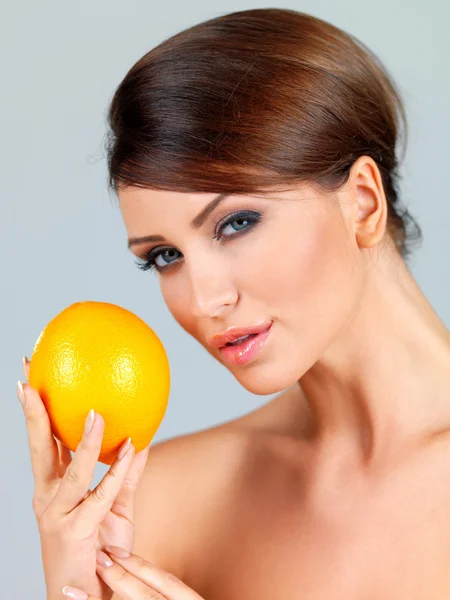 Sensuell kvinna med en orange — Stockfoto