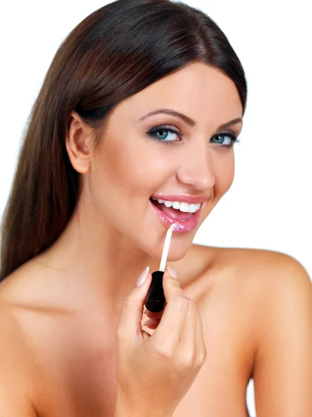 Beautiful woman applying lip gloss Stock Photo