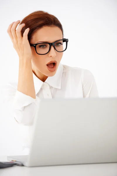 Geschockte Geschäftsfrau blickt auf ihren Laptop — Stockfoto