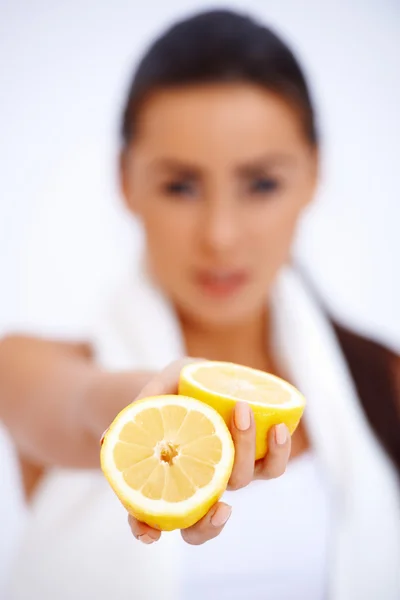 Close up of a woman showing fresh lemon — Stockfoto