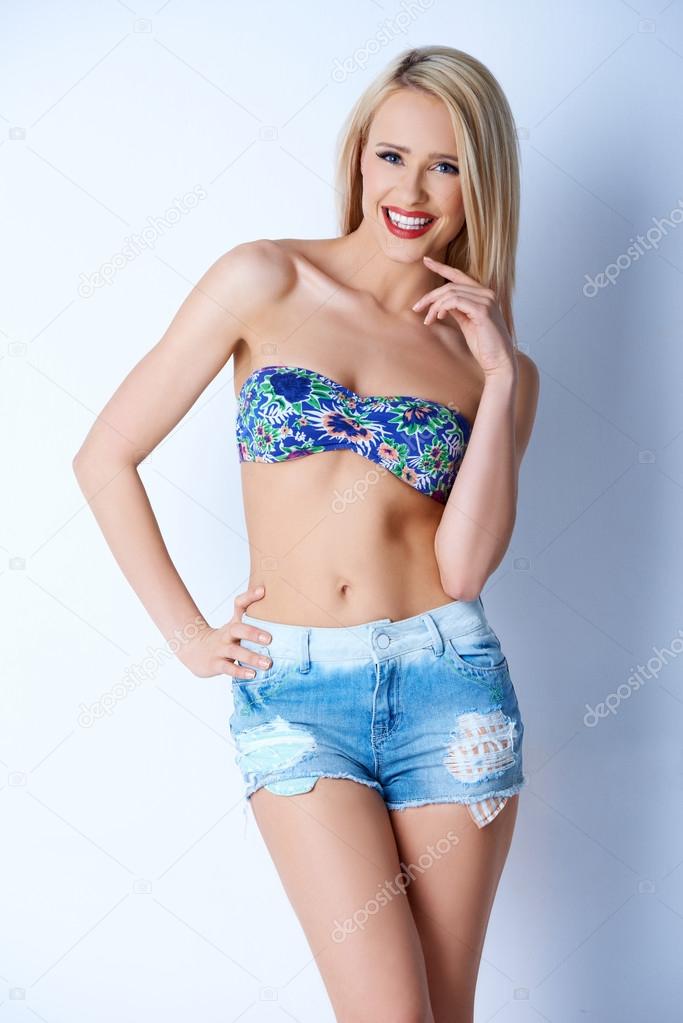 Blond sexy woman in short jeans and bikini bra Stock Photo by