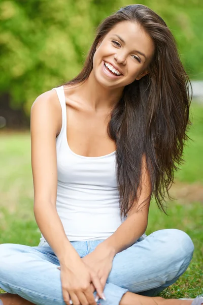 Šťastná mladá bruneta relaxační v parku — Stock fotografie