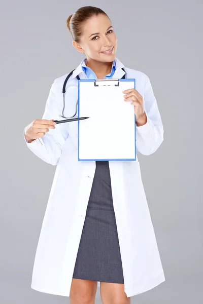 Female doctor displaying a blank clipboard — Stock Photo, Image