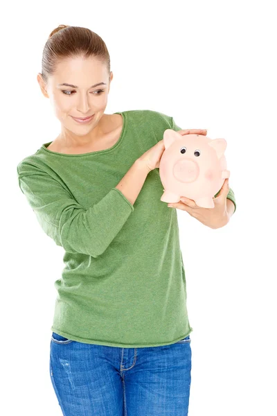 Frau gibt ihrem Sparschwein einen spekulativen Blick — Stockfoto