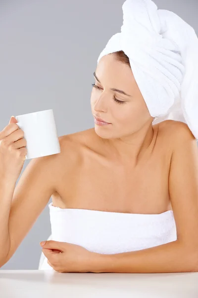 Mujer en un spa mirando una taza de café — Foto de Stock