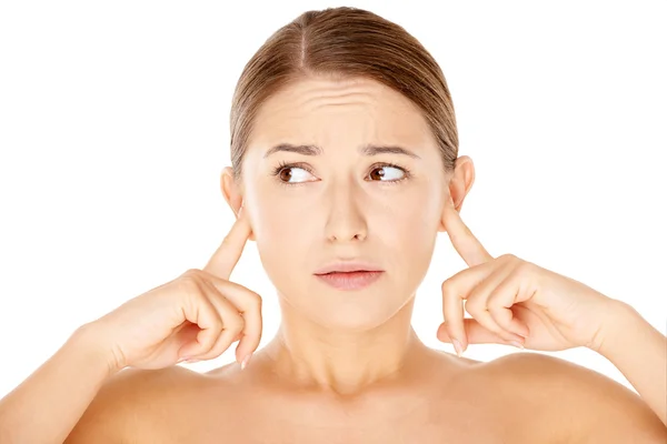 Kvinnan blockerar hennes öron med fingrarna — Stockfoto