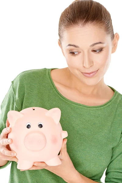 Frau gibt ihrem Sparschwein einen spekulativen Blick — Stockfoto