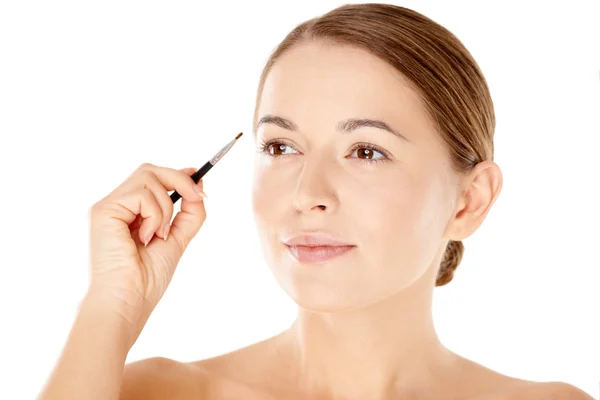 Beautiful woman with a small cosmetics brush Stock Picture