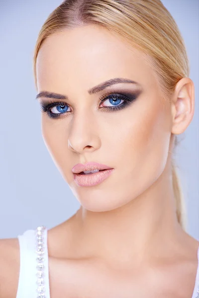 Mulher de olhos azuis bonita usando maquiagem — Fotografia de Stock