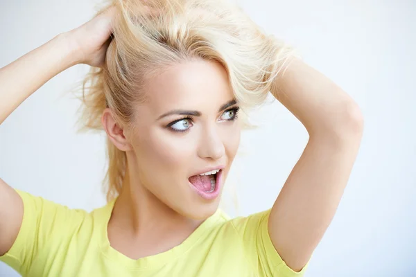 Mujer rubia frustrada mussing encima de su pelo largo — Foto de Stock