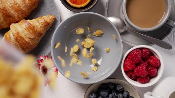 Verter los copos de maíz en el tazón del desayuno. Cayendo desde arriba — Vídeos de Stock