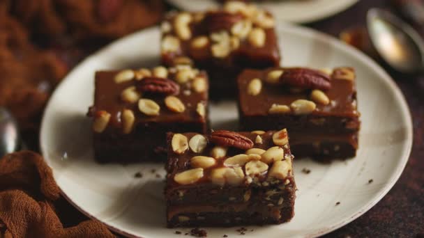 Schokoladenkuchen mit Karamell-Zuckerguss, Pekannüssen und heißem Kaffee auf rustikalem Hintergrund. Frisch gebacken — Stockvideo