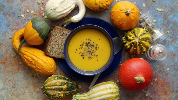 Kompozycja z jesiennym klasycznym jedzeniem. Smaczna zupa dyniowa domowej roboty ozdobiona czarnymi nasionami — Wideo stockowe