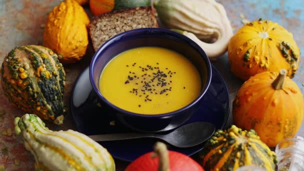 Compositon con comida clásica de otoño. Sabrosa sopa de calabaza casera decorada con semillas negras — Vídeos de Stock