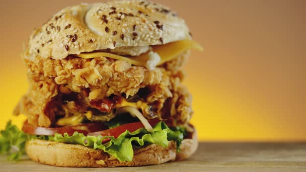 Hamburguesa de pollo crujiente con queso cheddar, lechuga, tomate y cebolla — Vídeo de stock