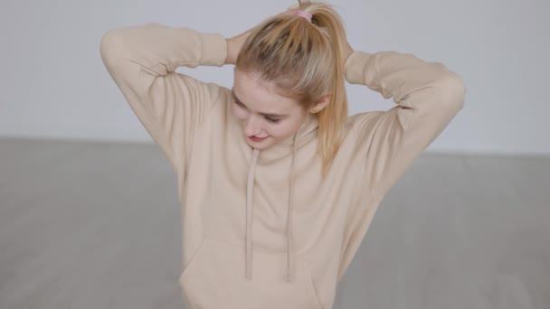 Vidám szőke nő kapucnis pulcsiban — Stock videók
