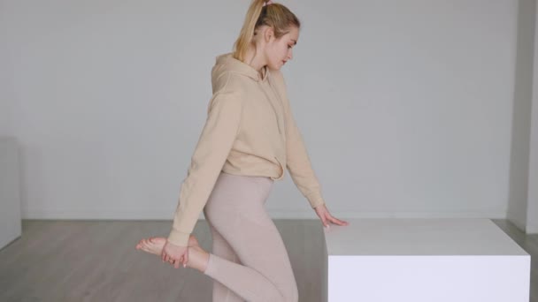 Passar kvinnlig atlet stretching ben nära kub — Stockvideo