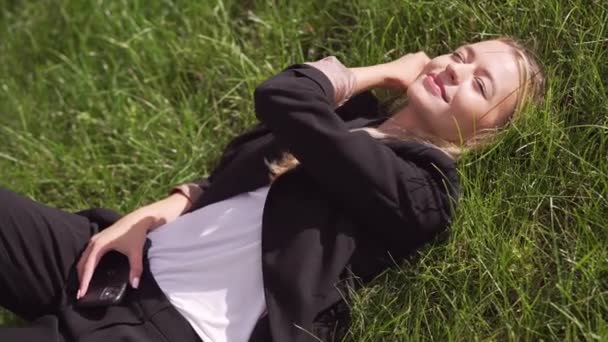 Junge Frau liegt auf Gras — Stockvideo