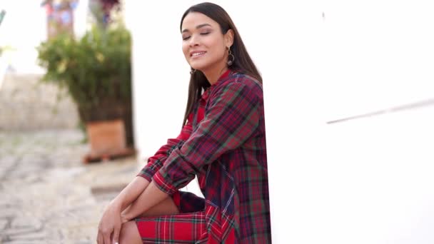 Femme ethnique souriante assise dans la rue — Video