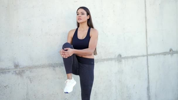 Positive young hispanic woman in stylish tracksuit doing stretching exercises – Stock-video