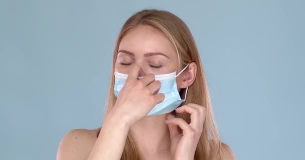 Søt, ung jente som tar på seg ansiktsmasken mot virus. Langsom film – stockvideo
