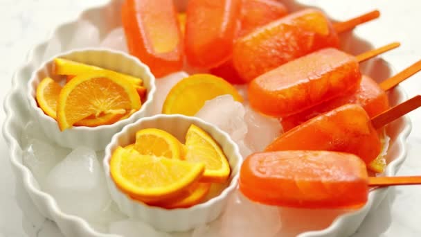 Caseiro, suculento, gelado de laranja. Colocado em uma placa branca com cubos de gelo — Vídeo de Stock