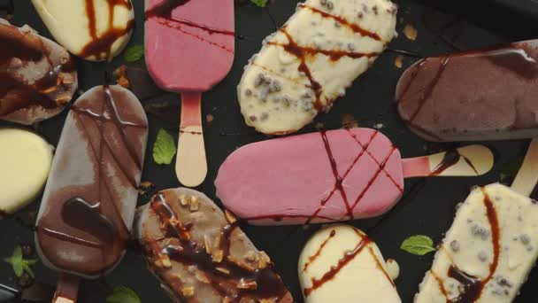 금속 쟁반에 담아 놓은 막대 위에 맛있는 흰색의 우유 초콜릿 과 딸기 아이스크림 세트 — 비디오