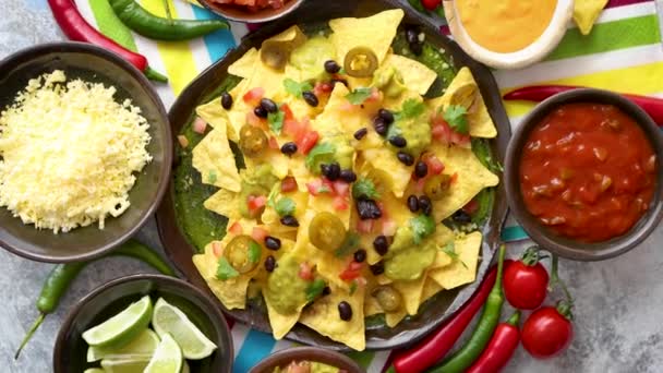 Tortillas de nachos mexicanos con frijol negro, jalapeño, guacamole — Vídeos de Stock