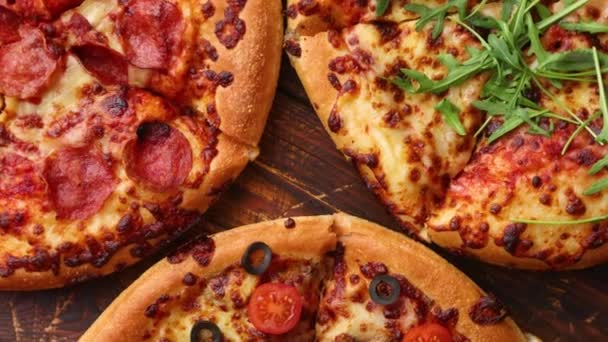 Drie Amerikaanse stijl pizza 's geserveerd op een tafel — Stockvideo