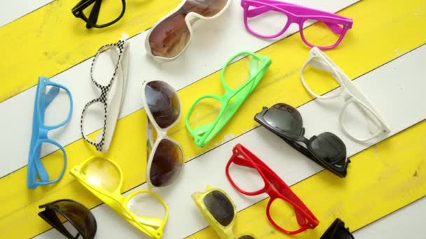 Kolekce různých stylů a barev slunečních brýlí a rámečků pořízených shora. — Stock video