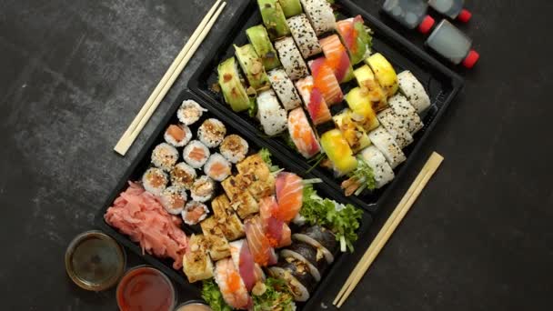 Asiatisk matleverans hem, olika sushi uppsättningar i plastbehållare med såser, ris och ätpinnar — Stockvideo