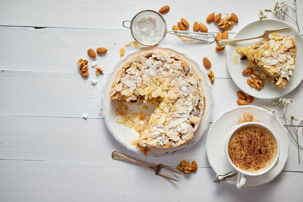 Whole delicious apple cake with almonds served on wooden table Stock Picture