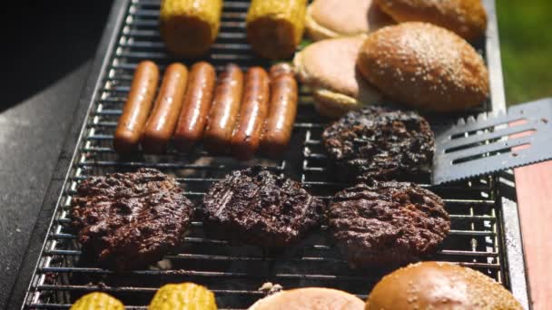 ホットグリルで混合アメリカのバーベキュー食品 ハンバーガー ホットドッグ トウモロコシを焼きます おいしい構成 屋外パーティー — ストック動画