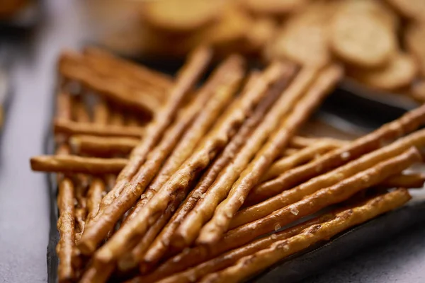 Close up of Salty sticks on a plate with crackers. Traditional beer and party snacks